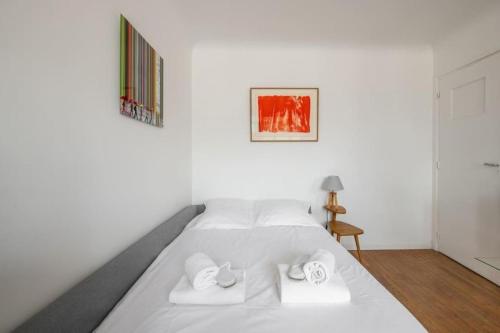 ein weißes Bett mit zwei Handtüchern darüber in der Unterkunft PARIS 6EME - Studio in Paris