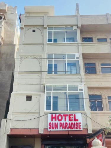 Una señal de hotel Sun Paradise frente a un edificio en HOTEL SUN PARADISE, en Jaipur