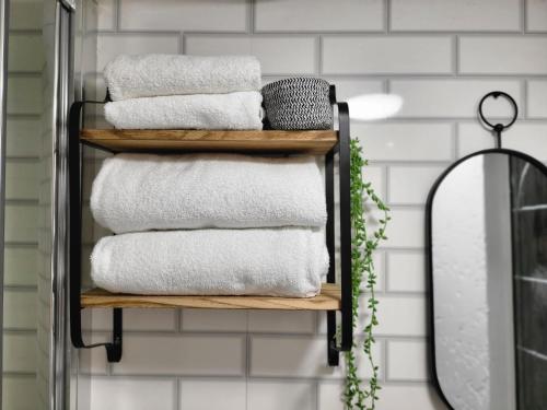 a stack of towels on a shelf in a bathroom at INNit Townhouse in London