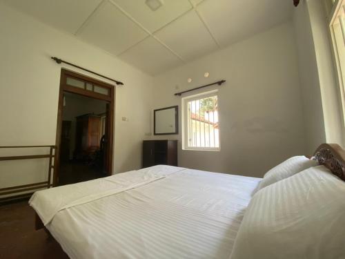 ein Schlafzimmer mit einem weißen Bett und einem Fenster in der Unterkunft Nature Korale in Galle