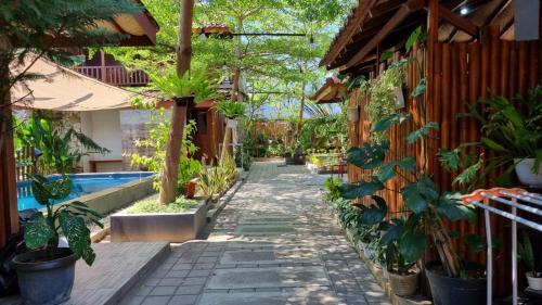 un pasillo ajardinado con plantas y una piscina en Vila Mas Banana Leaf Vila, en Kejayan