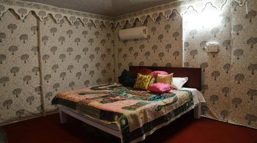 a bedroom with a bed with pillows and a window at Elefantastic in Jaipur
