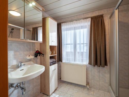 uma casa de banho com um lavatório e uma janela em Haus Hofbichl em Itter