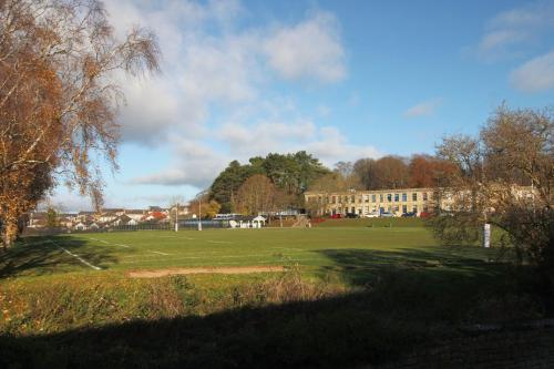 a large green field with a building in the background at Cohost Partners- FREE Parking Close to town in Bath