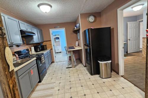 uma cozinha com um frigorífico preto e piso em azulejo em Naut Tonight at The Holler em Frogue