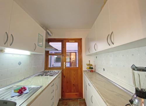 kuchnia z białymi szafkami i piekarnikiem w obiekcie Apartamento Bella Vista w mieście Tabaiba
