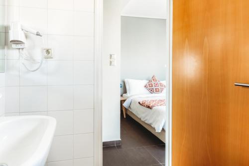 a bathroom with a sink and a bed in a room at Athens Studios in Athens