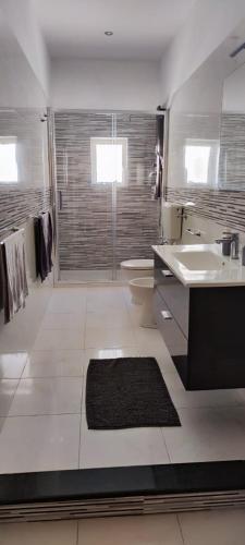 a bathroom with a toilet and a sink and a shower at Happy Home in Pozzallo