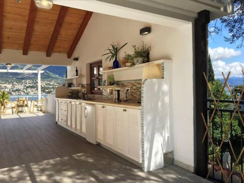 an outdoor kitchen with white cabinets and a balcony at Zazenda House in Herceg-Novi