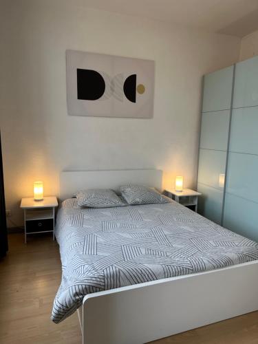 um quarto com uma cama com duas mesas e dois candeeiros em Appartement Climatisé La Gallinette em Perpignan