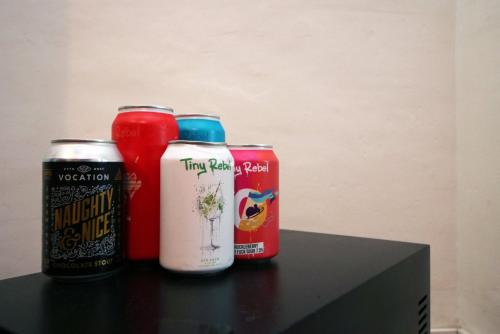a table with two cans of beer and a can of soda at Parking | 2BR | Luxurious in Cardiff
