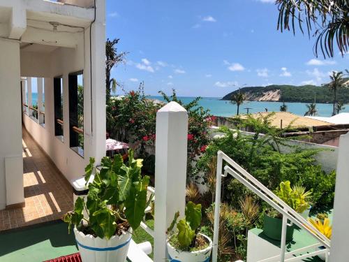 a balcony with potted plants and a view of the ocean at Ponta Negra Suites & Apart in Natal