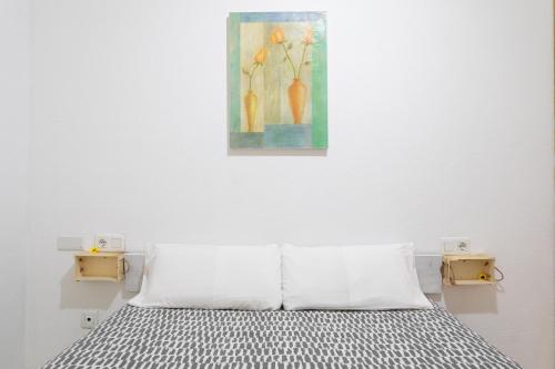 um quarto com uma cama com um quadro na parede em Sunflower Italia em Santa Pola