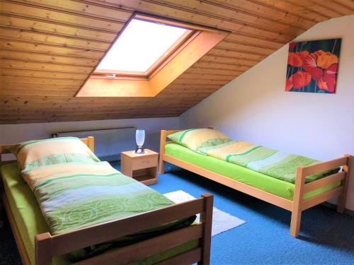 a attic room with two beds and a skylight at Haus Evi in Neusorg