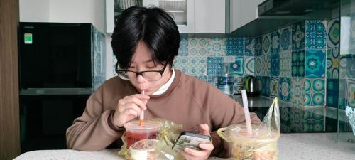 a person sitting at a table eating food with a straw at Private homestay sea view in Halong center in Ha Long