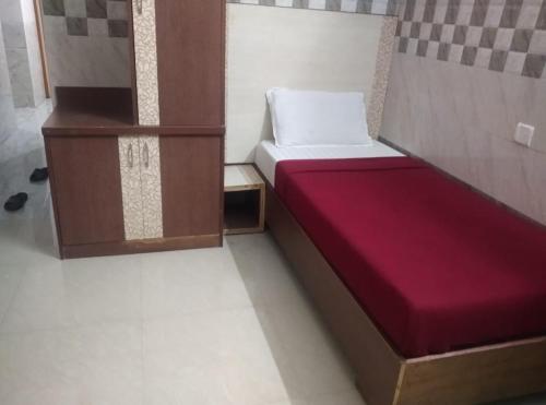 Habitación pequeña con cama con colchón rojo en Surya's Guest House, en Chennai