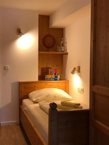 a bedroom with a bed with a wooden headboard at Gästehaus Hotel Maria Theresia in Schliersee
