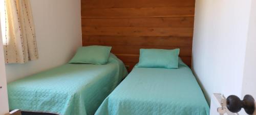 - deux lits assis l'un à côté de l'autre dans une pièce dans l'établissement Refugio familiar, à Pucón