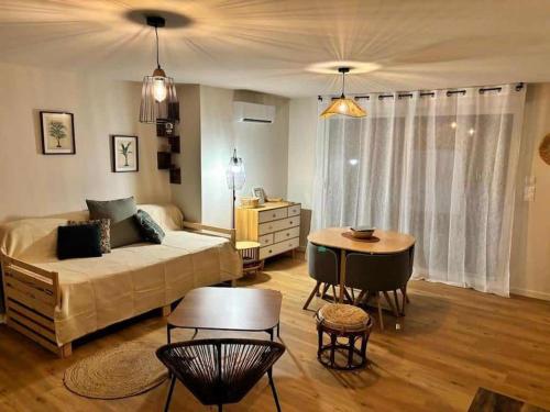 - un salon avec un lit et une table dans l'établissement Au p'tit soleil - Charmant T2 en Provence, à Barjols