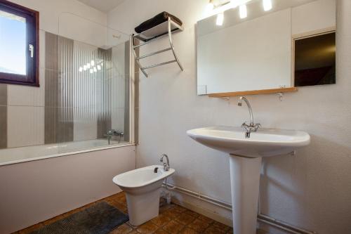 a white bathroom with a sink and a toilet at Chalet de 6 chambres avec vue sur la ville balcon et wifi a Briancon a 1 km des pistes in Briançon