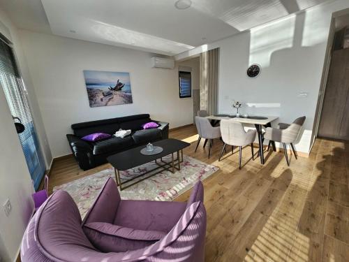 Hedonica 2 New Apartment في فردنيك: غرفة معيشة مع أريكة أرجوانية وطاولة