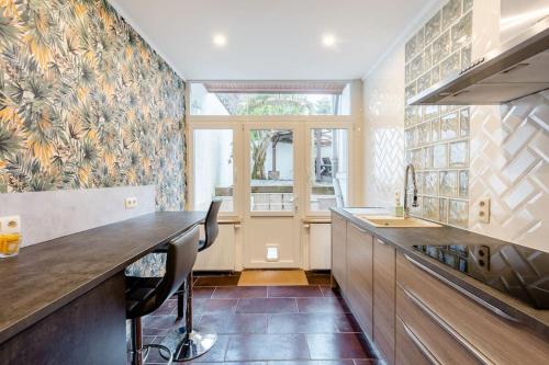 une cuisine avec un comptoir et une grande fenêtre dans l'établissement Magnolia Green Garden New and fully equipped, à Bruxelles