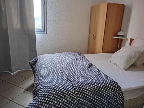 - un lit avec une couette en noir et blanc dans l'établissement Appartement T2 en RDC avec terrasse, piscine, et parking - FR-1-195-47, au Barcarès