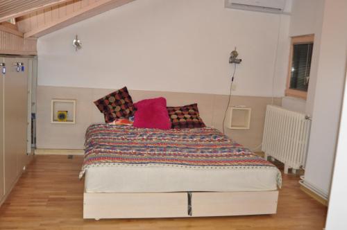 a bedroom with a bed with colorful pillows on it at Luxury Apartment with parking space in Vodno