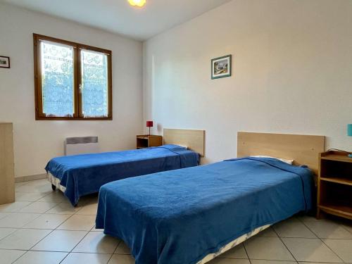 twee bedden in een kamer met blauwe lakens bij Maison Argelès-sur-Mer, 3 pièces, 6 personnes - FR-1-225-14 in Argelès-sur-Mer