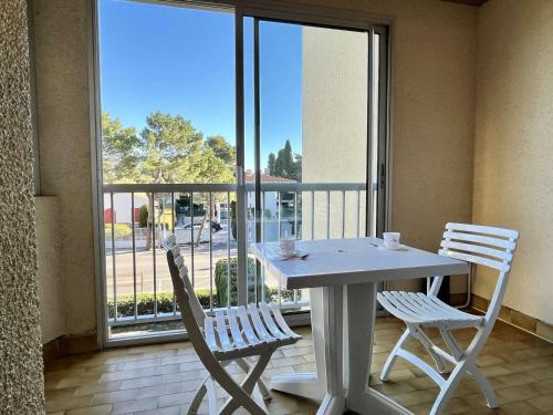 d'une table blanche et de deux chaises sur un balcon avec vue. dans l'établissement Appartement 2 pièces à 400m de la plage avec parking privé, loggia et ménage inclus - Argelès-sur-Mer - FR-1-225-247, à Argelès-sur-Mer