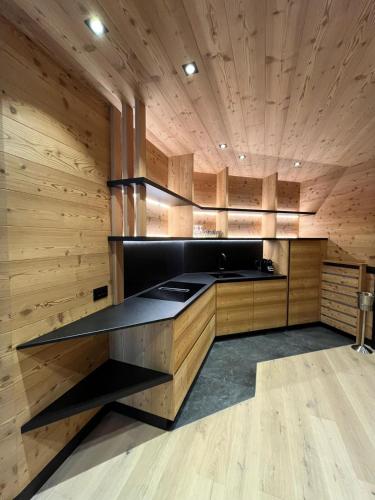 a kitchen with wooden walls and a black counter top at Chalet Residence Alpinflair in Ortisei