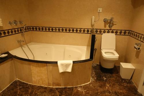 a bathroom with a bath tub and a toilet at Sun-n-Sand Shirdi in Shirdi
