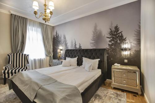 a bedroom with a large bed and a chair at Hotel Palace in Sinaia