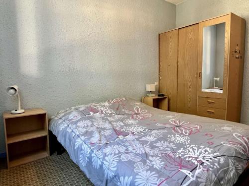 une chambre avec un lit avec une couette bleue et blanche dans l'établissement Appartement confortable à 100m de la plage d'Argelès-sur-Mer, balcon, 4 couchages, TV, proche commerces - FR-1-225-673, à Argelès-sur-Mer