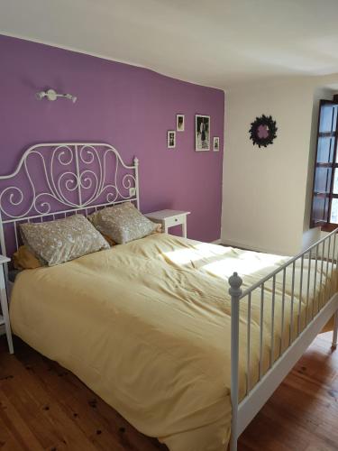 a bedroom with a bed with a purple wall at La antigua in Villarcayo