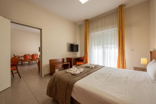 a bedroom with a large bed and a dining room at The Originals Boutique, Hotel l'Occitan, Aubagne in La Destrousse