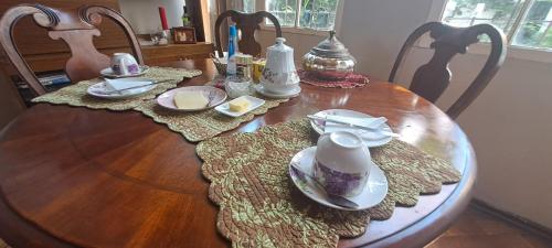 a wooden table with plates and dishes on it at Ñuñoa Sunrise B&B in Santiago