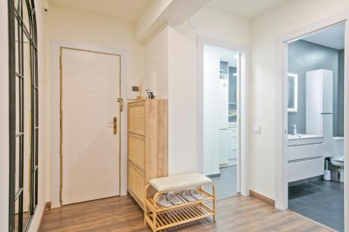 een badkamer met een witte deur en een kruk bij Apartamento soleado y acogedor in Barcelona