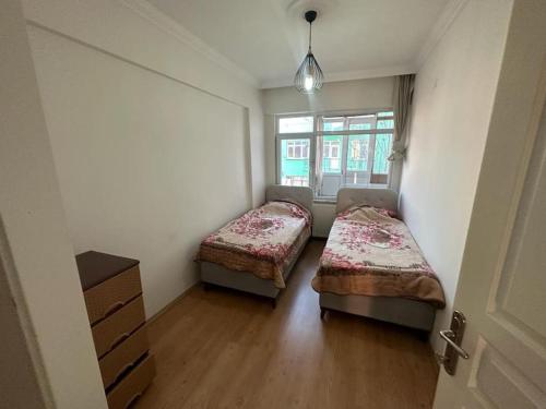 2 Betten in einem kleinen Zimmer mit Fenster in der Unterkunft شقة بإطلالة على الشاطئ 4 Apartment with beach view in Silivri