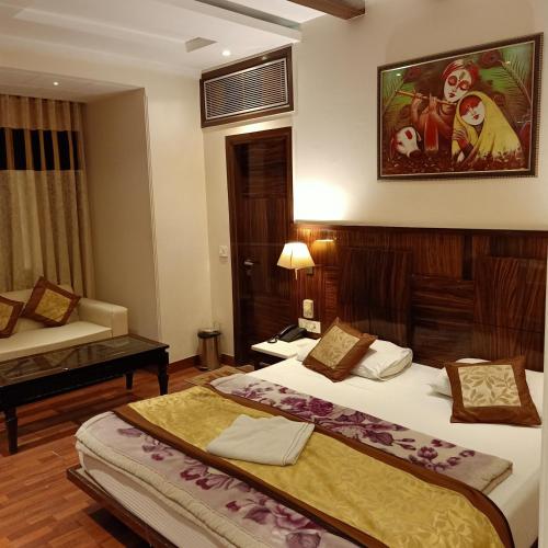 a hotel room with two beds and a couch at hotel geet deluxe in New Delhi