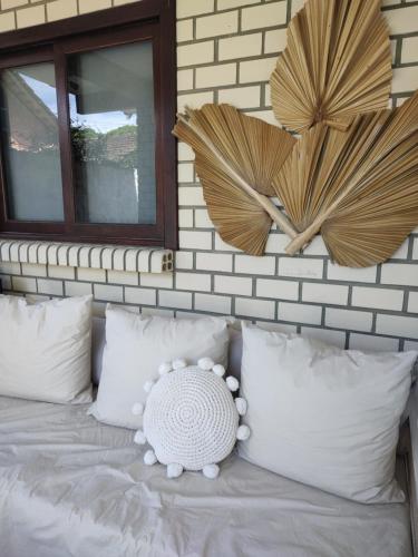 een slaapkamer met een bed met witte kussens en spiegels bij Residencial e Pousada Acauan in Guarda do Embaú