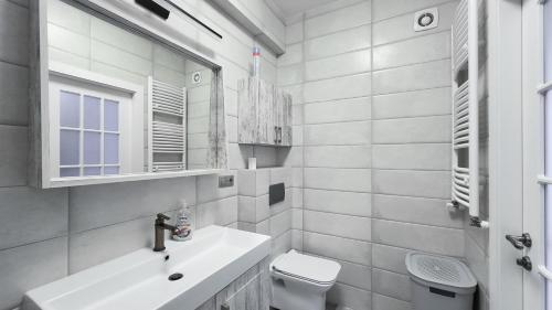 uma casa de banho branca com um lavatório e um WC em Glass New Apartments Ultracentral em Chisinau