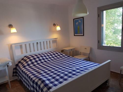 een slaapkamer met een blauw en wit bed en een raam bij Villa Hekim in Bodrum City