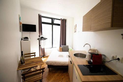 une cuisine avec un évier et un salon dans l'établissement Studio 2 personnes proche Gare du Nord, à Paris