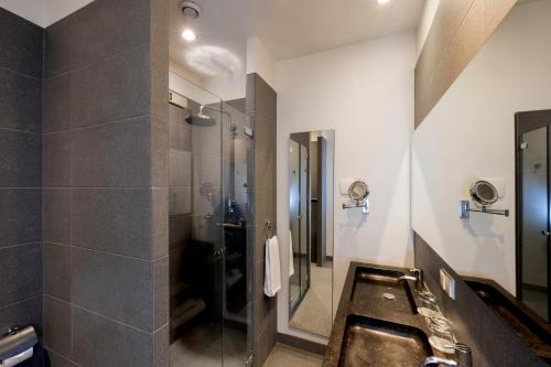 a bathroom with a sink and a shower at Catalonia Vondel Amsterdam in Amsterdam