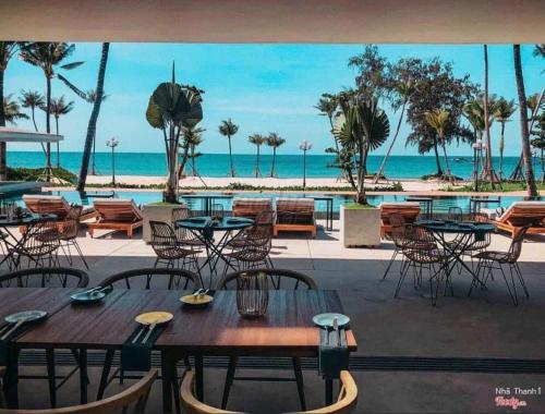 een uitzicht op het strand vanuit een restaurant met tafels en stoelen bij Phu Quoc villa in Marina Resort beach swimming pool in Phu Quoc