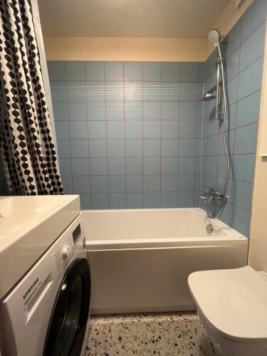 a washing machine in a bathroom with a toilet at LITTLE LONDON boutique apartment with Netflix, top location in Old Town in Narva
