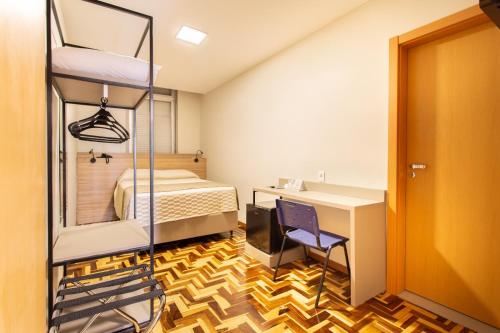 a room with a bed and a desk and a bunk bed at Hotel Dom Rafael Business in Santa Maria