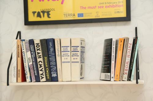 a shelf full of books on a wall at LITTLE LONDON boutique apartment with Netflix, top location in Old Town in Narva