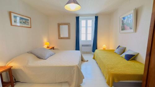 een slaapkamer met 2 bedden en een raam bij Maison de village en 2 parties in Saint-Clément-des-Baleines